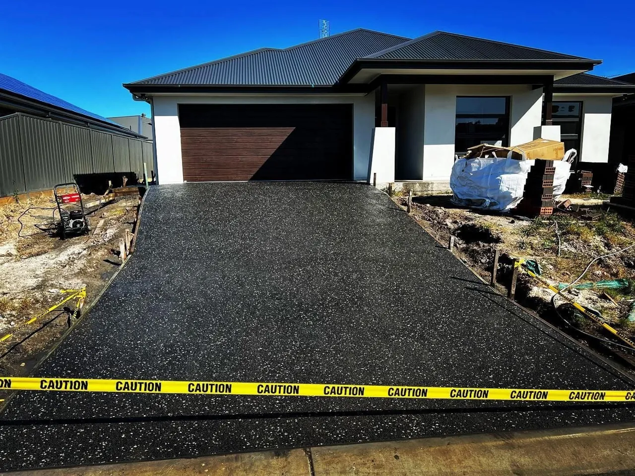Charcoal concrete driveway poured by Desired Concrete & Landscapes on the Central Coast